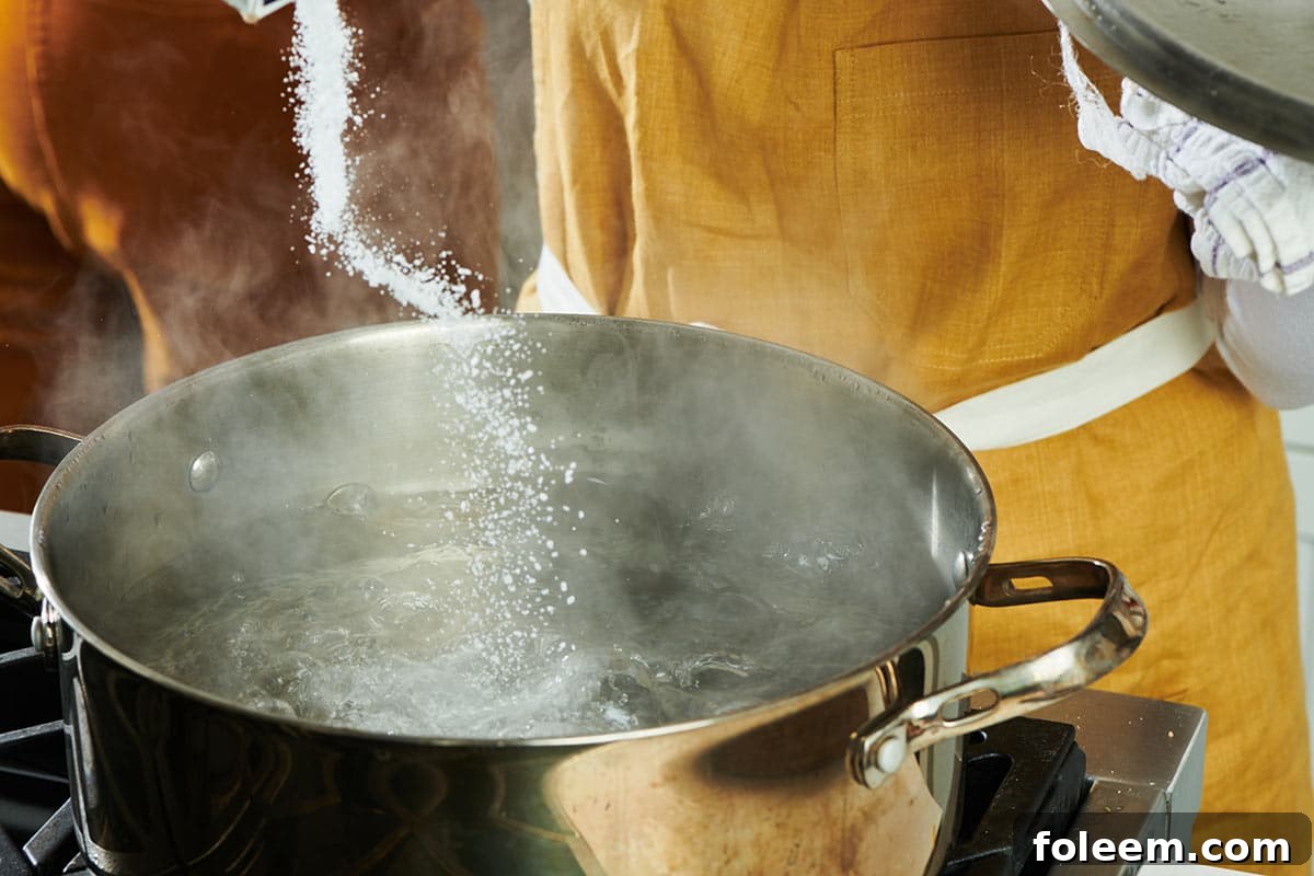 Adding salt to boiling water for pasta.