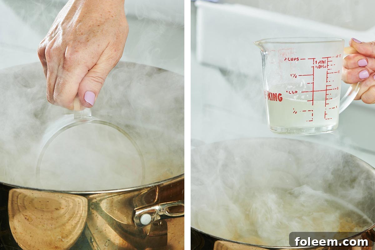 Measuring cup scooping water from boiling pot of pasta.