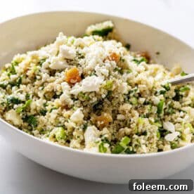 Kale Quinoa Salad with Honey, Lemon and Dijon Dressing in large white serving dish with spoon.