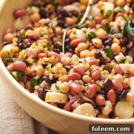 Bean salad in brown serving bowl on table.