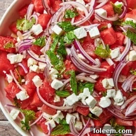 Watermelon Feta Salad in white serving dish on wood table.