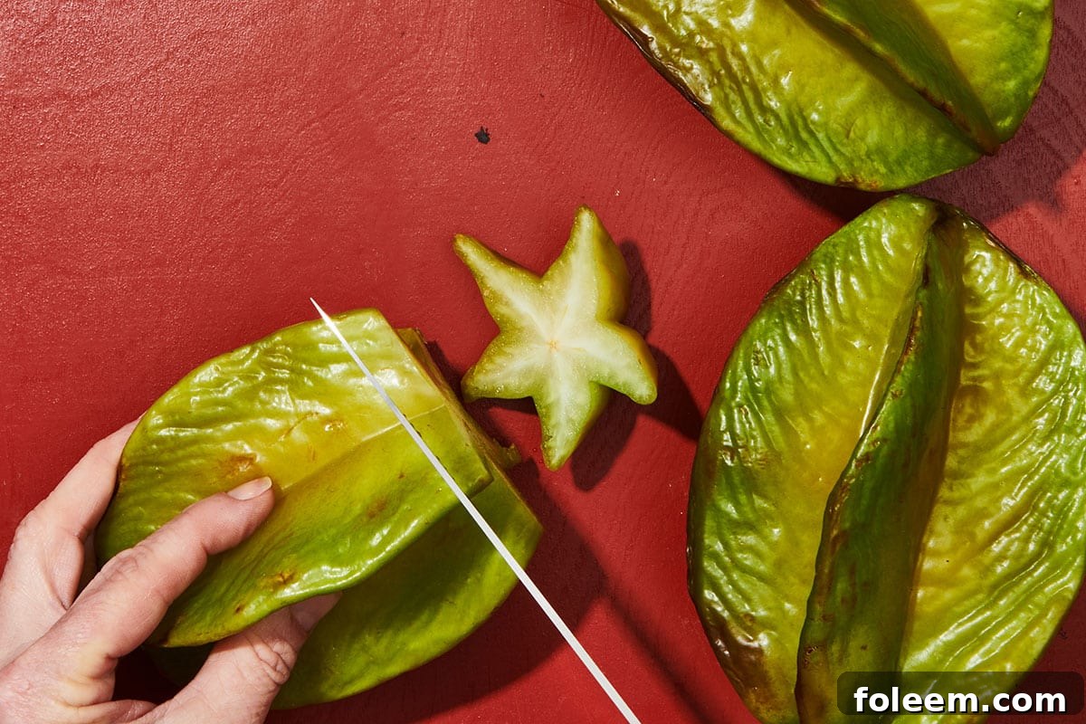 Woman cutting ends off starfruit.