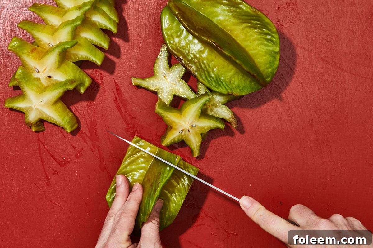 Woman slicing fresh starfruit.