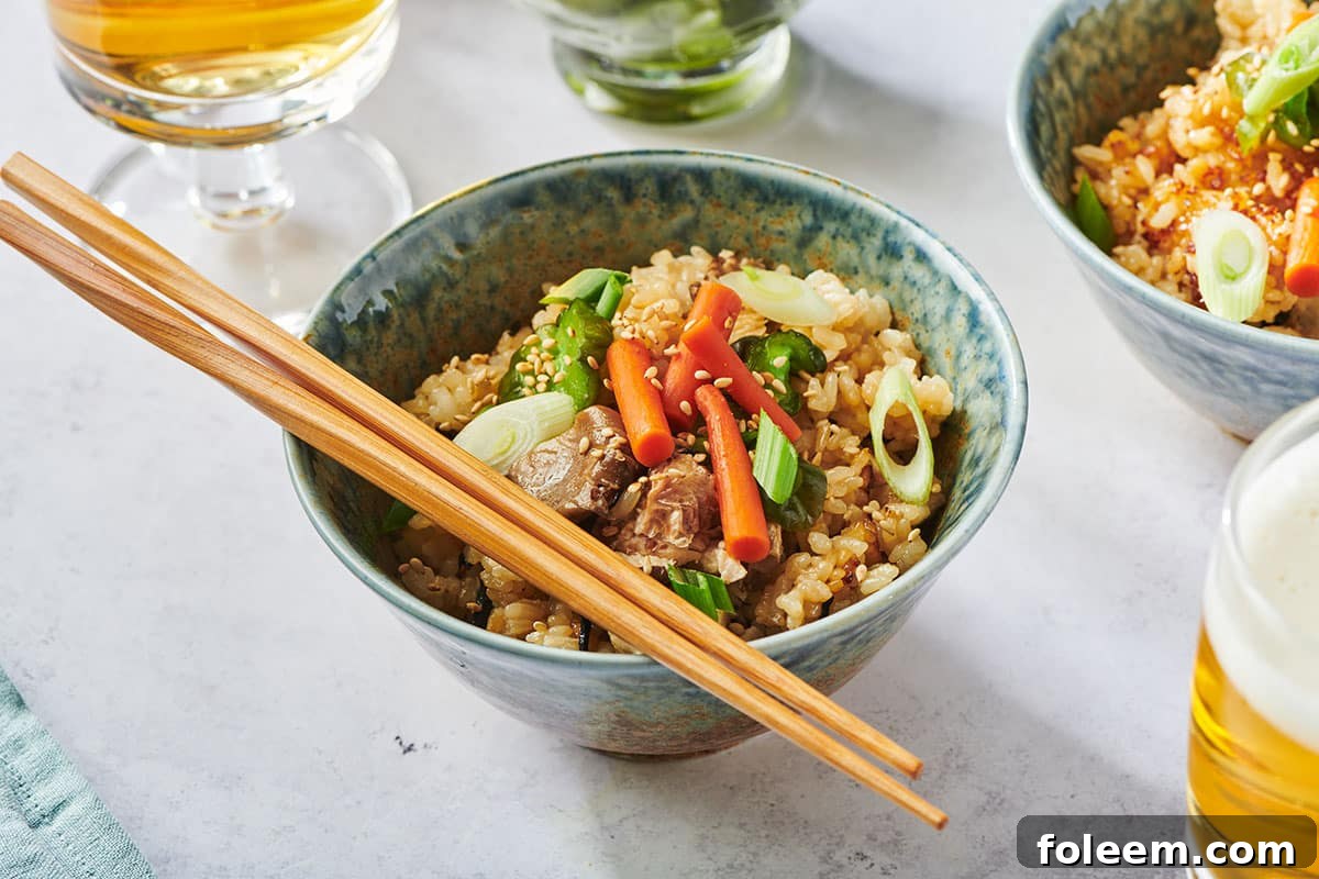 Takikomi gohan with chicken in grey bowl with chopsticks.