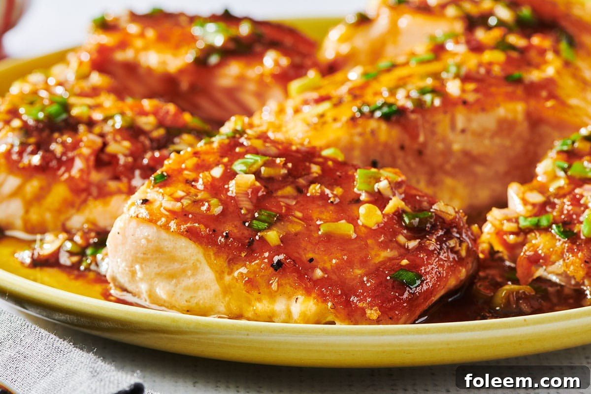 Ginger and lemongrass salmon filets piled on yellow plate.