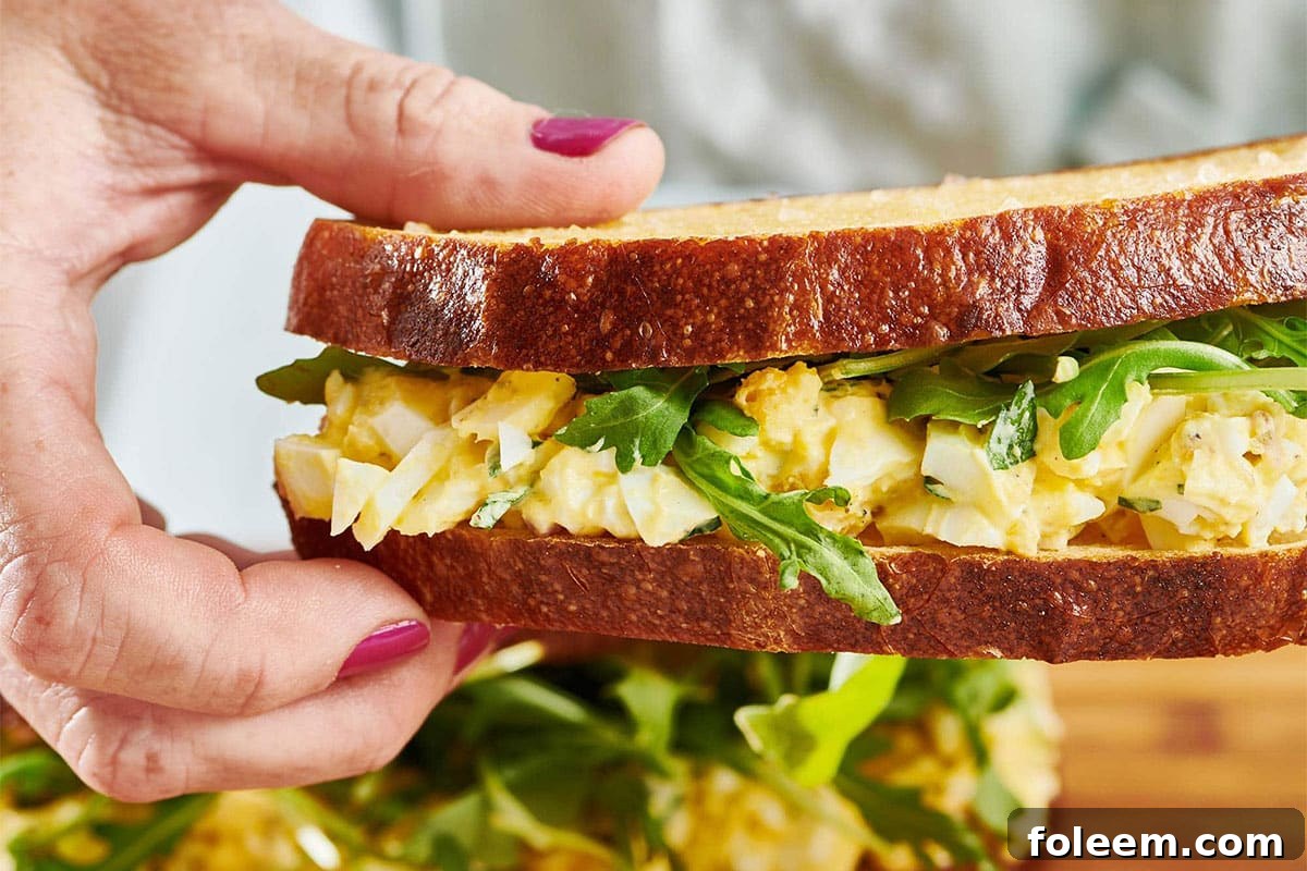 Woman holding an Egg Salad sandwich.