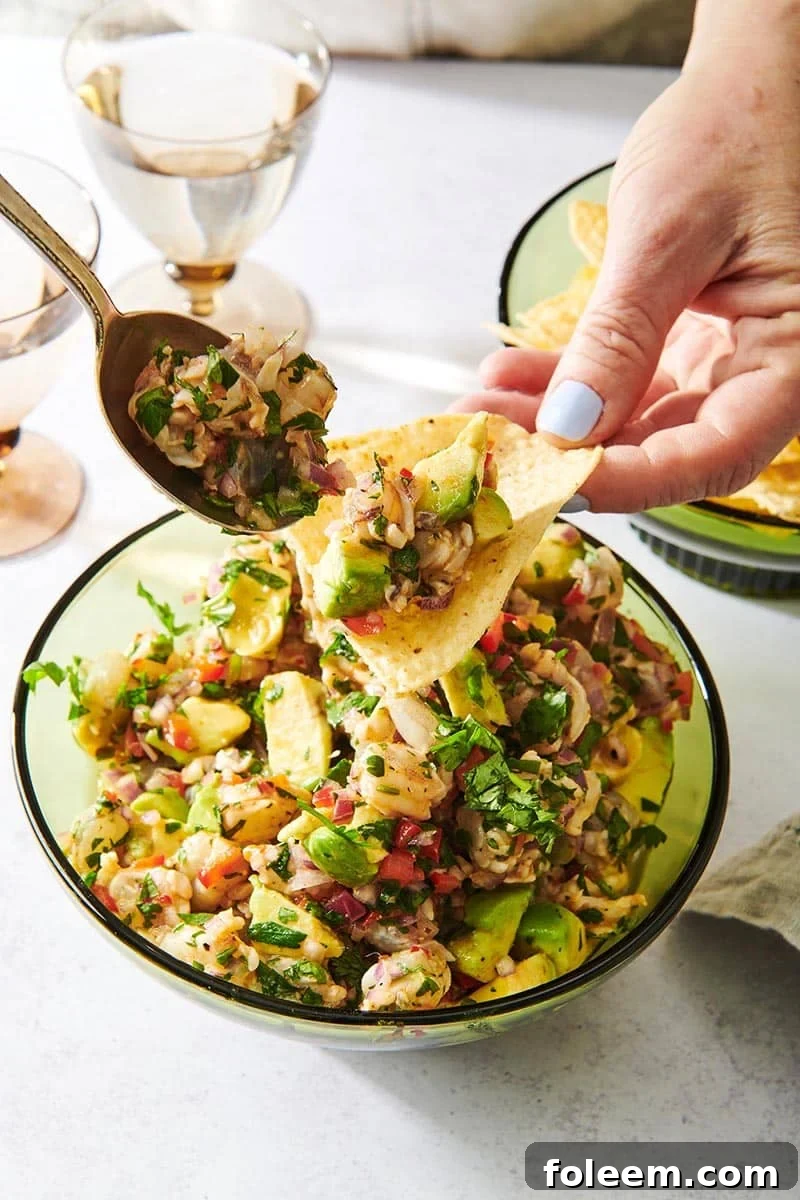 Spoon putting Shrimp Ceviche onto a tortilla chip.