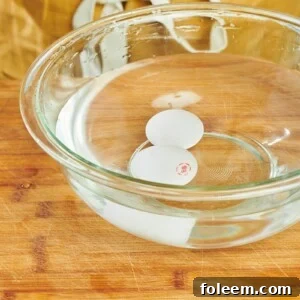 Eggs sitting in glass bowl of water.