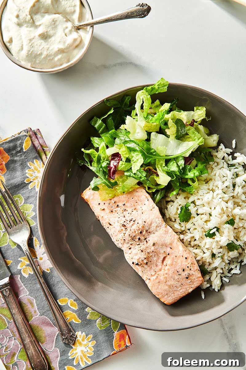 Salmon with Dill Sauce on grey plate with veggie sides.