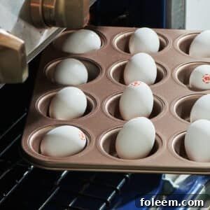 Placing muffin tin of raw eggs in oven for hard-boiled eggs.