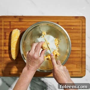 Cutting kernels from sweet corn cob in bowl.