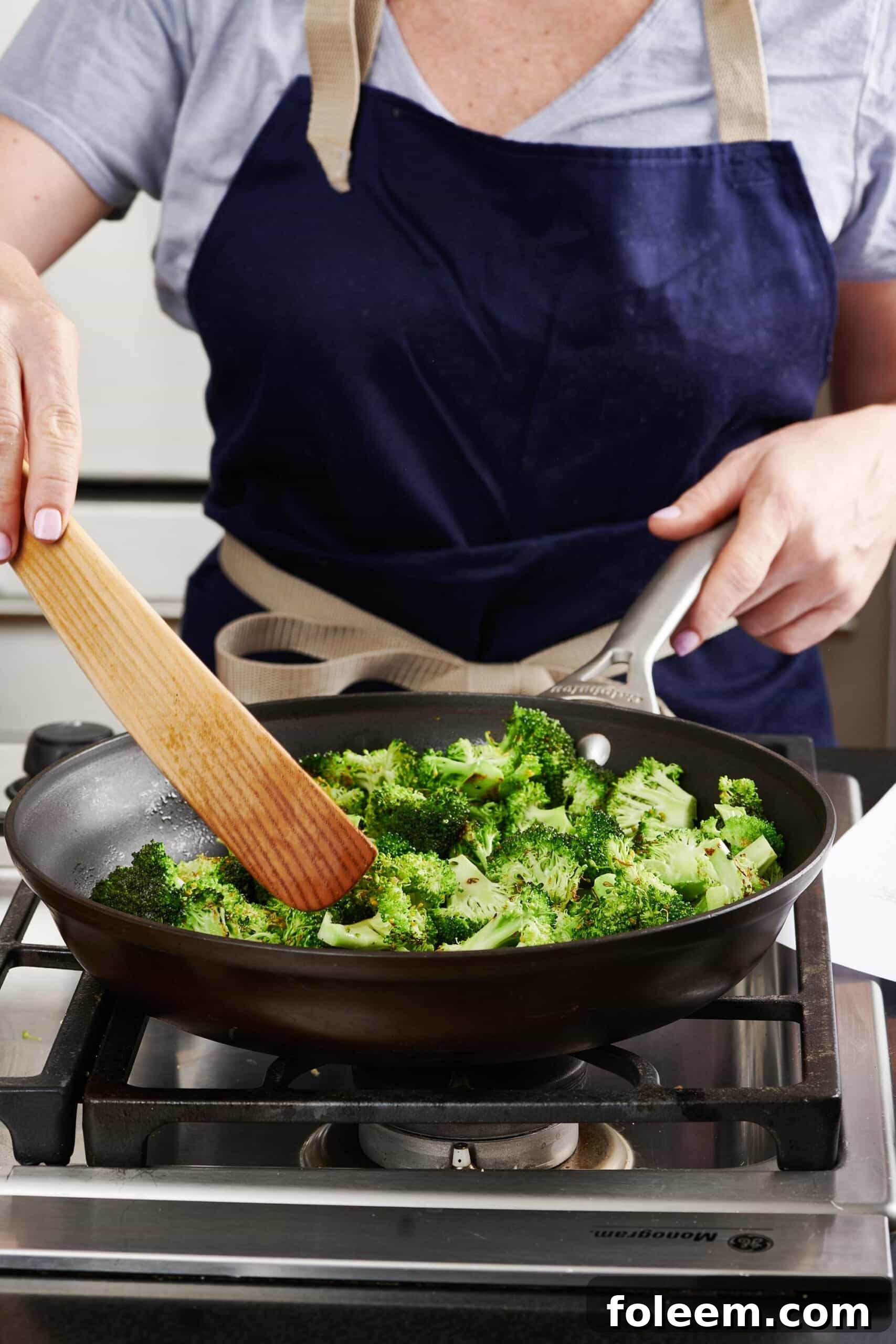 Stir-frying broccoli in wok.