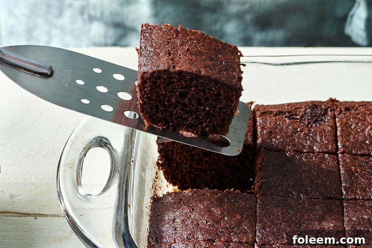 Spatula grabbing a piece of Gingerbread Cake from a baking pan.